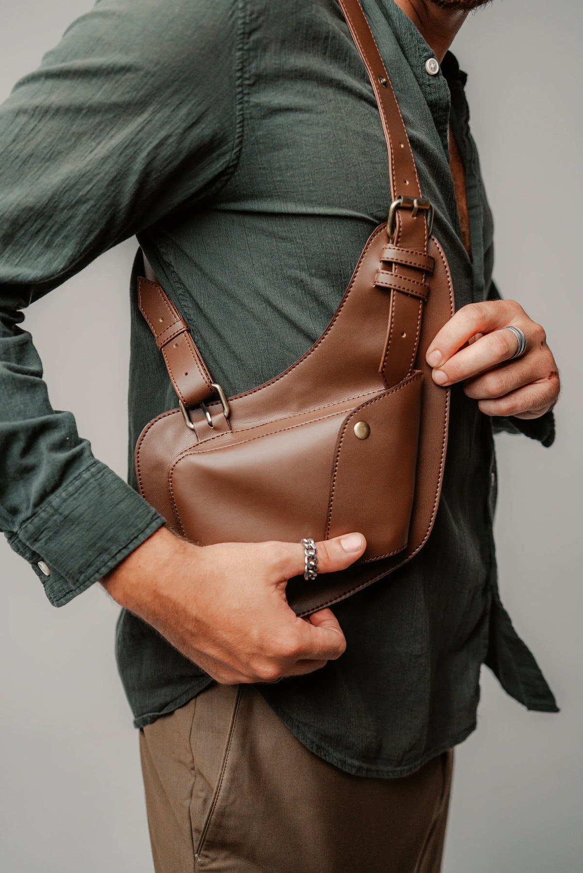 Brown Lashasana shoulder holster bag worn with a green jacket